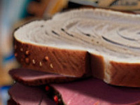 Illustration of a pastrami sandwich with a time travel clock swirl behind it